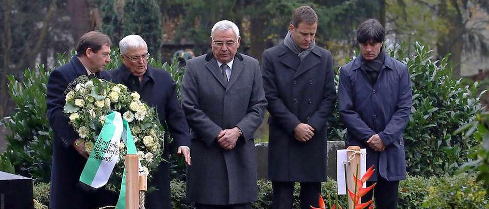 DFB-Präsident Theo Zwanziger (2.v.l.) beobachtet am 10. November 2010 zusammen mit Oliver Bierhoff (2. v. r.) und Joachim Löw (r.) die Kranzniederlegung am Grab von Robert Enke.