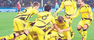 Gelbe Haufenbildung. Die Dortmunder Spieler treffen anlässlich des Freiburger Eigentores zum 2:1 spontan und gut gelaunt zusammen. Foto: dpa