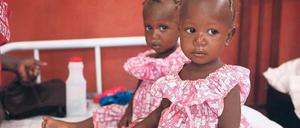 Wo die Kameras sind, sind auch die Hilfsorganisationen. Sie brauchen Bilder, vorzugsweise von Kindern, um im Kampf um den großen Spendenkuchen zu bestehen. Fotos wie dieses, mit zwei kleinen Schwestern in einem Krankenlager in Haiti, gehen um die ganze Welt.