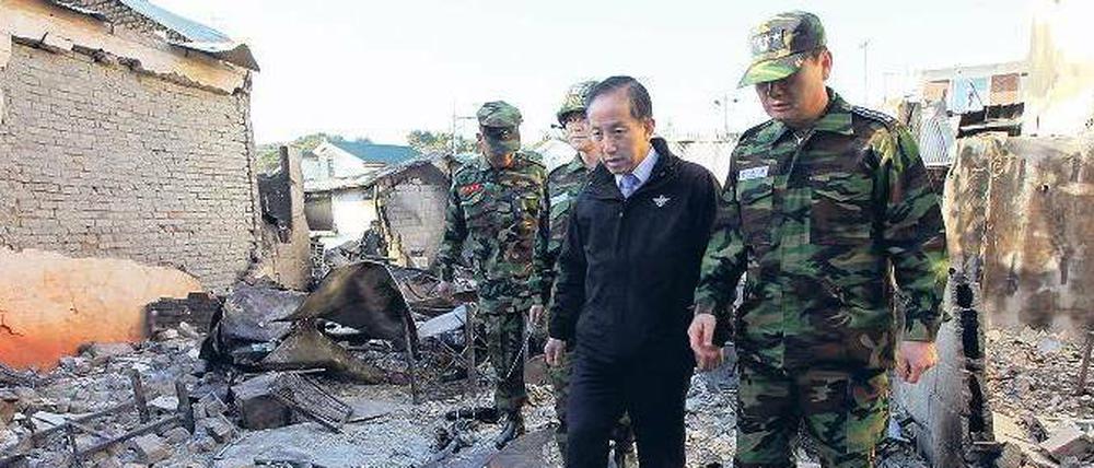 Am Ort der Zerstörung. Südkoreas Verteidigungsminister Kim Tae Young (Mitte) auf der Insel Yeonpyeong. Der Minister ist am Donnerstag zurückgetreten.