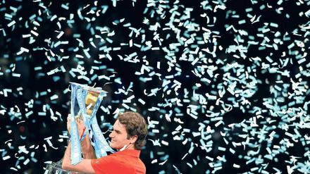 Warum regnet es immer auf mich? Roger Federer stemmt nach seinem Sieg im Finale der World Tour seine Trophäe in die Luft. Foto: AFP