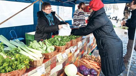 Marktlücke. Dörte (links) und Gerhard Ihler (hinten in der Mitte) verkaufen ihre selbst angebauten Lebensmittel aus der Uckermark auf dem Arkonaplatz in Mitte. Foto: Georg Moritz