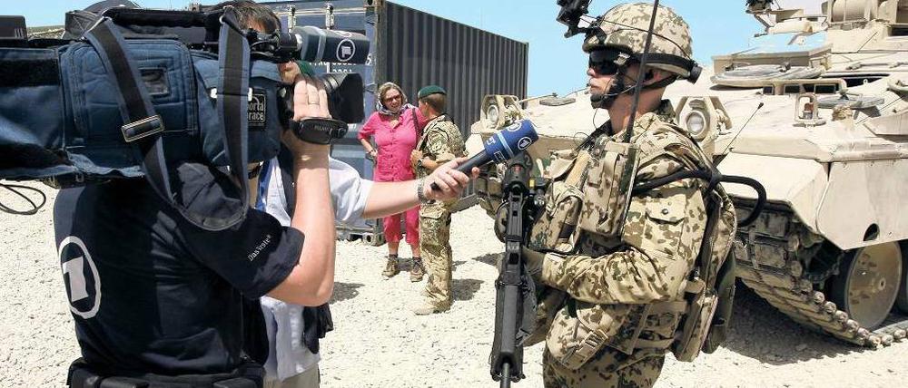 Soldat mit Schützenpanzer. Bei einem sogenannten Medientag stellt sich die Bundeswehr den Fragen und der Nachfrage der Journalisten aus Deutschland. Foto: Maurizio Gambarini/dpa
