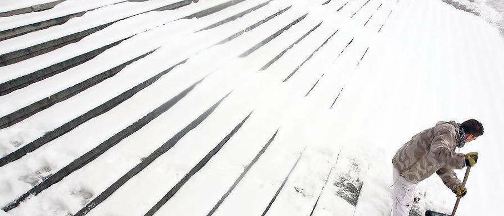 Eingeschneit. Nach neuem Schneefall wurde am Mittwoch wieder allerorten geschippt und gefegt. Auch am Alten Museum in Mitte mussten die Treppen freigeschaufelt werden. Die Meteorologen sagen für die kommenden Tage winterliche Temperaturen und weitere Schneefälle voraus. Foto: dpa/Stephanie Pilick