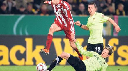 Hürde übersprungen. Bayern Münchens Thomas Müller (l.) lässt sich von Aachens Tobias Feisthammel nicht stoppen. Foto: dpa