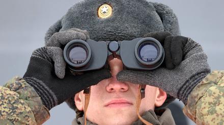 Ein russischer Soldat beobachtet ein Truppenmanöver.  