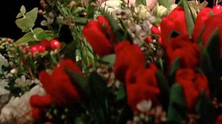Ein bisschen Lächeln kann jeder: Olaf Scholz hinter Blumen.