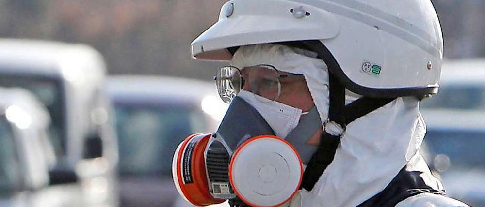 Ein Polizist mit Atemschutzgerät bei der Evakuierung des Gebietes rund um das Atomkraftwerk Fukushima.