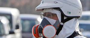 Ein Polizist mit Atemschutzgerät bei der Evakuierung des Gebietes rund um das Atomkraftwerk Fukushima.