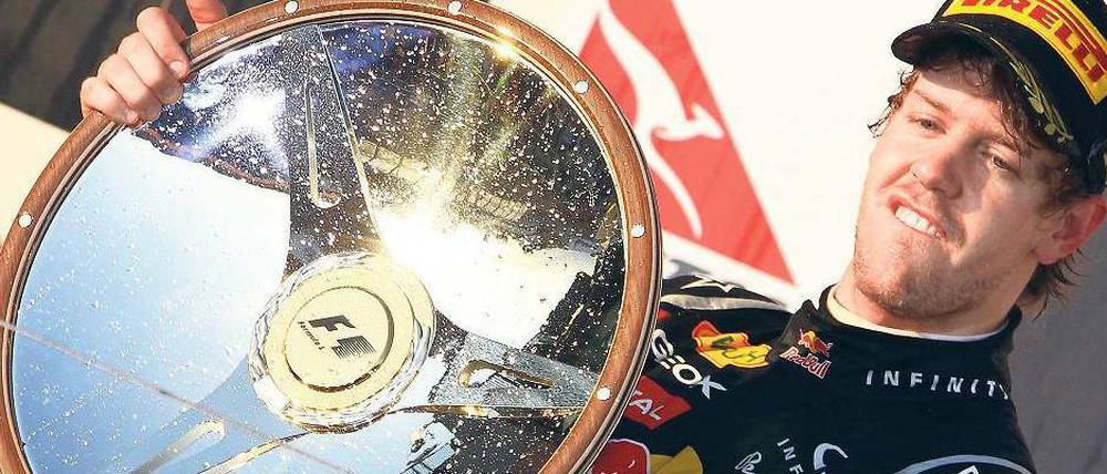 Er fährt und fährt und … Die Form der Trophäe ließ es zu, dass Sebastian Vettel seiner Lieblingsbeschäftigung auch noch auf dem Siegerpodest nachgehen konnte. 