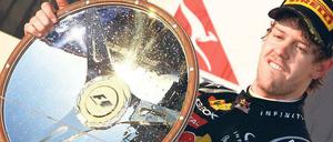 Er fährt und fährt und … Die Form der Trophäe ließ es zu, dass Sebastian Vettel seiner Lieblingsbeschäftigung auch noch auf dem Siegerpodest nachgehen konnte.