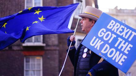 "Brexit git the UK done" steht auf einem Plakt, das ein Mann bei seinem Anti-Brexit-Protest zusammen mit einer Europa-Fahne vor dem Lancaster House in London zeigt. +++ dpa-Bildfunk +++