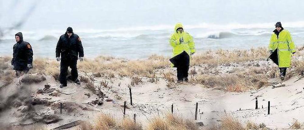 Grausige Suche. Polizeikadetten suchen am Strand in der Nähe der Wohnanlage Oak Beach auf Long Island nach weiteren Opfern eines Serienmörders. Acht Leichen wurden bisher geborgen, die letzten drei am Montagabend. Bei allen handelt es sich um junge Frauen. Der Täter hatte sie in Sackleinen verpackt und im dichten Gebüsch der Strände Gilgo und Oak Beach versteckt. Foto: Andrew Gombert/dpa