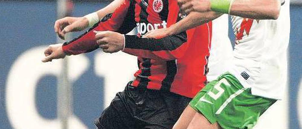 Doppelte Manndeckung. Frankfurts Tzavellas wird von den Bremern Fritz (l.) und Wesley (r.) in die Zange genommen. Foto: dpa