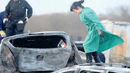 Ein Unfallort wird zum Tatort. Eine Forensikerin inspiziert ausgebrannte Wracks und tote Insassen. Polizei und Justiz untersuchen eingehend die Ursache und den Verlauf der Unfallkatastrophe auf der A 19. Fotos: Reuters (1), dpa(2)
