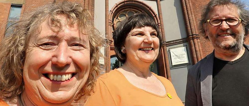 Strahlen um die Wette. Die Künstlerinnen Carolyn Krüger (l.) und Brigitte Kottwitz (Bildmitte) vor der Emmaus-Kirche.