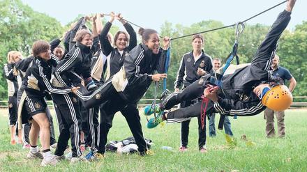 Drahtseilakt. Die deutschen Fußballerinnen lassen ihre Mitspielerin Fatmire Bajramaj (rechts) beim Teambuilding auf Insel Scharfenberg im Tegeler See hängen. 