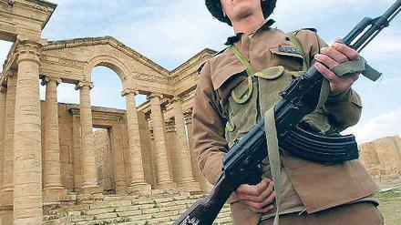 Denkmal in Gefahr. Ein Wachposten patrouilliert in der Ruinenstadt Hatra im Irak. Nach dem Zusammenbruch des Saddam-Regimes wurden viele antike Stätten geplündert. 