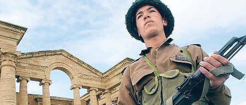 Denkmal in Gefahr. Ein Wachposten patrouilliert in der Ruinenstadt Hatra im Irak. Nach dem Zusammenbruch des Saddam-Regimes wurden viele antike Stätten geplündert. 