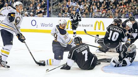 Vorbei an Freund und Gegner: Buffalos Adam (links) erzielt ein Tor und schaut den Los Angeles Kings beim erfolglosen Verteidigen zu. Foto: dapd