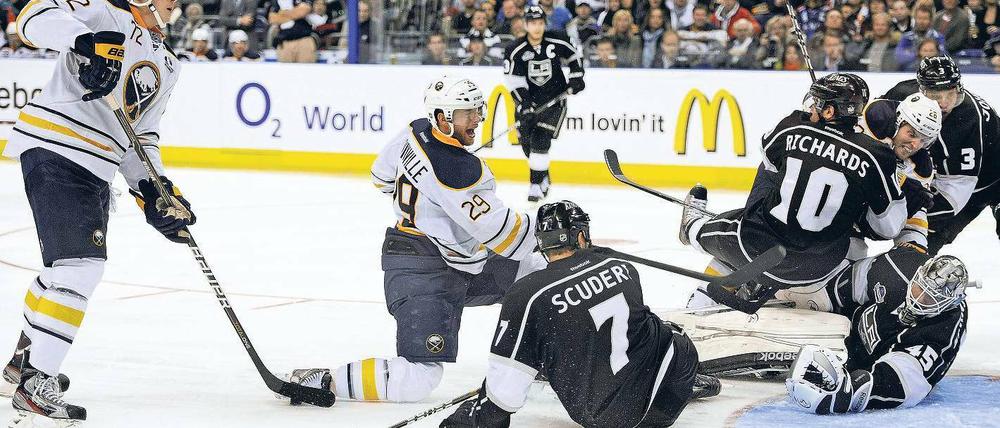 Vorbei an Freund und Gegner: Buffalos Adam (links) erzielt ein Tor und schaut den Los Angeles Kings beim erfolglosen Verteidigen zu. Foto: dapd