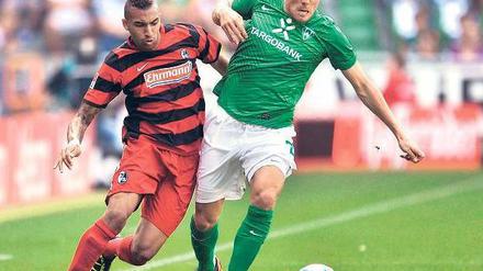 Wieder Sieger. Clemens Fritz (r. , gegen den Freiburger Daniel Williams) weist die besten Zweikampfwerte bei Werder auf.Foto: dpa