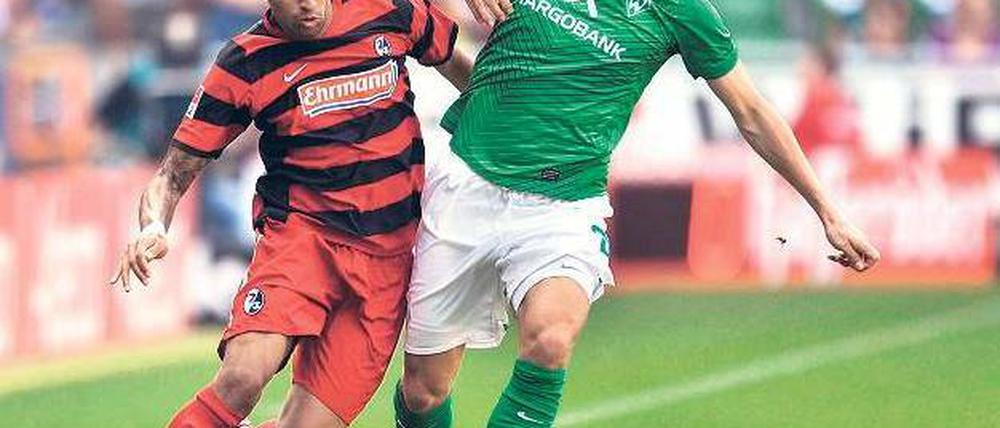 Wieder Sieger. Clemens Fritz (r. , gegen den Freiburger Daniel Williams) weist die besten Zweikampfwerte bei Werder auf.Foto: dpa