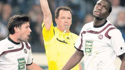 Der Mann im Mittelpunkt. Schiedsrichter Peter Sippel zeigt dem Lauterer Rodnei (rechts) die Rote Karte; zuvor hatte es schon Schalkes Torhüter Ralf Fährmann erwischt.