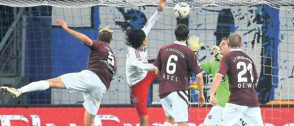 Drei Rote gegen einen Weißen. Paolo Guerrero kann sich dennoch durchsetzen und den Ausgleich für den Hamburger SV köpfen. Foto: dapd