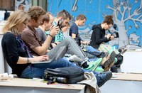 Besucher der Internetkonferenz Re:publica sitzen am 08.05.2013 in Berlin mit ihrem Laptop auf den Knien nebeneinander.