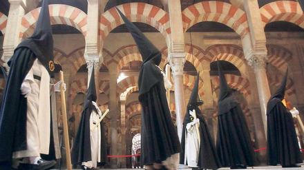 Ostern in Córdoba, religiöses Spektakel in Spanien. Mitglieder der „Hermandad del Amor“ (Bruderschaft der Liebe) marschieren durch den versteinerten Palmenhain der Mezquita, der großen Moschee, die zur christlichen Kirche wurde. Die Gestalten gehören zu den Prozessionen der Semana Santa. Foto dpa: