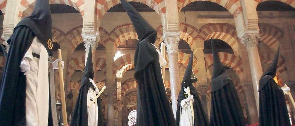 Ostern in Córdoba, religiöses Spektakel in Spanien. Mitglieder der „Hermandad del Amor“ (Bruderschaft der Liebe) marschieren durch den versteinerten Palmenhain der Mezquita, der großen Moschee, die zur christlichen Kirche wurde. Die Gestalten gehören zu den Prozessionen der Semana Santa. Foto dpa: