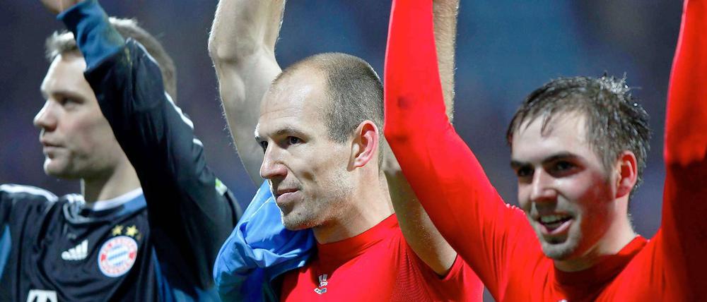 Münchens Torwart Manuel Neuer (v.l.), Arjen Robben und Philipp Lahm jubeln nach dem Spiel.