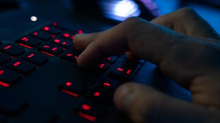 Ein Mann sitzt am Rechner und tippt auf einer Tastatur (Symbolbild).