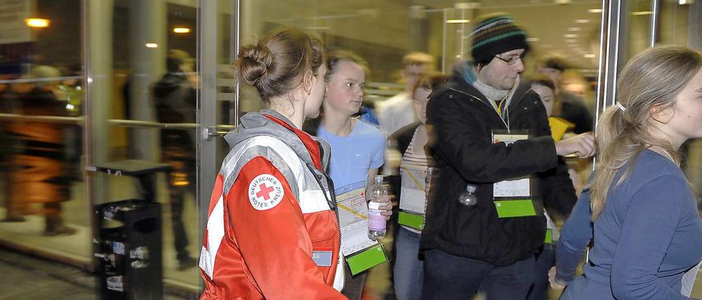 Rettungskräfte bringen Studenten in Sicherheit.