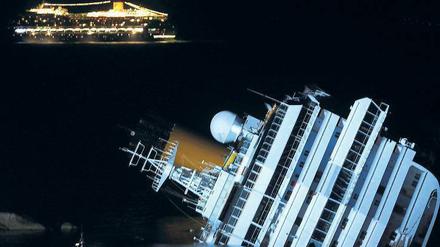 Unbeirrt. Während die Costa Concordia auf dem Felsen liegt, fährt ihr Schwesterschiff Costa Serena hell erleuchtet vorbei. Das Schiff fährt dieselbe Route wie die Costa Concordia und bietet das gleiche Programm. 