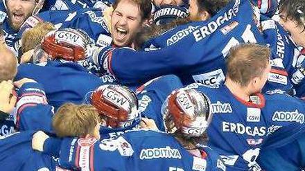Jubelknäuel. Die Spieler der Eisbären fallen sich nach Spielende euphorisch um den Hals. Foto: dpa