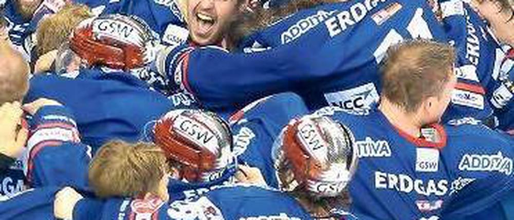 Jubelknäuel. Die Spieler der Eisbären fallen sich nach Spielende euphorisch um den Hals. Foto: dpa
