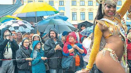 Sambafestival in Coburg. Die Besucher stehen im Regen, während sich die brasilianische Tänzerin die Laune nicht verderben lässt.