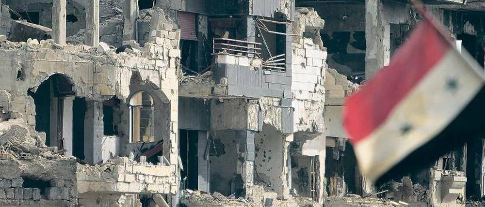 Furor der Zerstörung. Ansicht eines Straßenzugs Anfang Mai im Quartier Baba Amr in Homs mit syrischer Flagge. Das Bild entstand während einer von der Regierung geführten offiziellen Tour durch die einstmalige Hochburg der Widerständler.