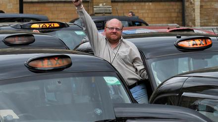 Ein Taxifahrer reckt am eine Faust in die Höhe während einer Protestkundgebung in London.