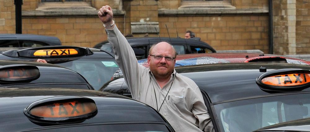 Ein Taxifahrer reckt am eine Faust in die Höhe während einer Protestkundgebung in London.