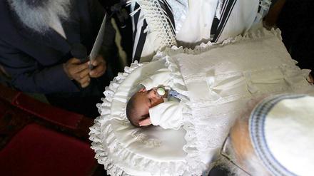 Zeremonie. Ein kleiner Junge wird beschnitten. Das Ritual ist in der jüdischen Tradition von großer Bedeutung – und heftig umstritten. 