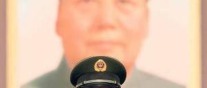 Ein Wächter steht am Tag der Entscheidung vor einem Porträt Mao Tse-tungs. Foto: AFP