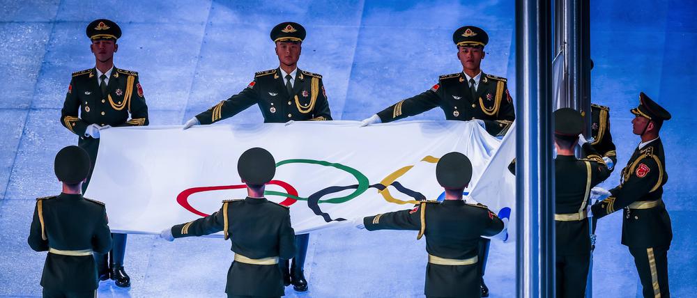 Soldaten von Chinas Volksbefreiungsarmee hissen während der Eröffnungsfeier im Pekinger Vogelneststadion die olympische Flagge.