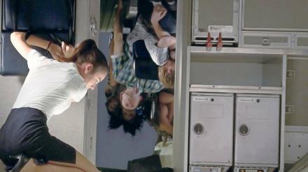 Fasten Seat Belts. Stewardess Trina (Nadine Velazquez) bemüht sich um Fassung in der Turbulenz. 