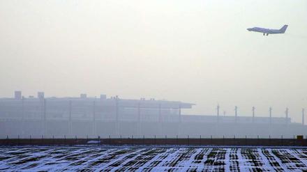 Ein Flugzeug über dem neuen Flughafen BER.