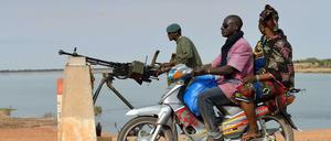 Die neue Normalität entlang des Nigers. Ein Motorrad fährt an einem Soldaten vorbei, der die Niger-Brücke von Markala bewacht. Die Brücke ist eine von drei festen Übergängen über den Fluss in Mali. Doch die Brücke bei Gao ist noch in den Händen der Islamisten. 