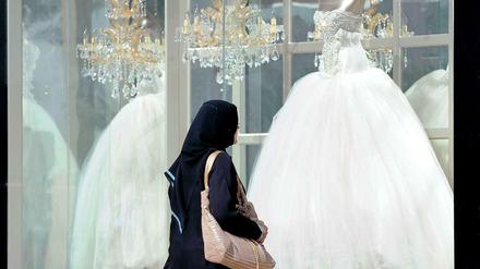 Zwischen Tradition und Moderne: Eine Frau betrachtet in der saudi-arabischen Hauptstadt Rijad ein Schaufenster mit Brautmoden