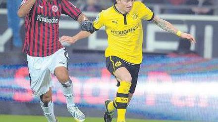 Auf und davon. Der Frankfurter Carlos Zambrano versucht vergeblich, den Dortmunder Marco Reus (rechts) aufzuhalten. Reus erzielte beim 3:0-Heimsieg des BVB alle drei Tore. Foto: dpa